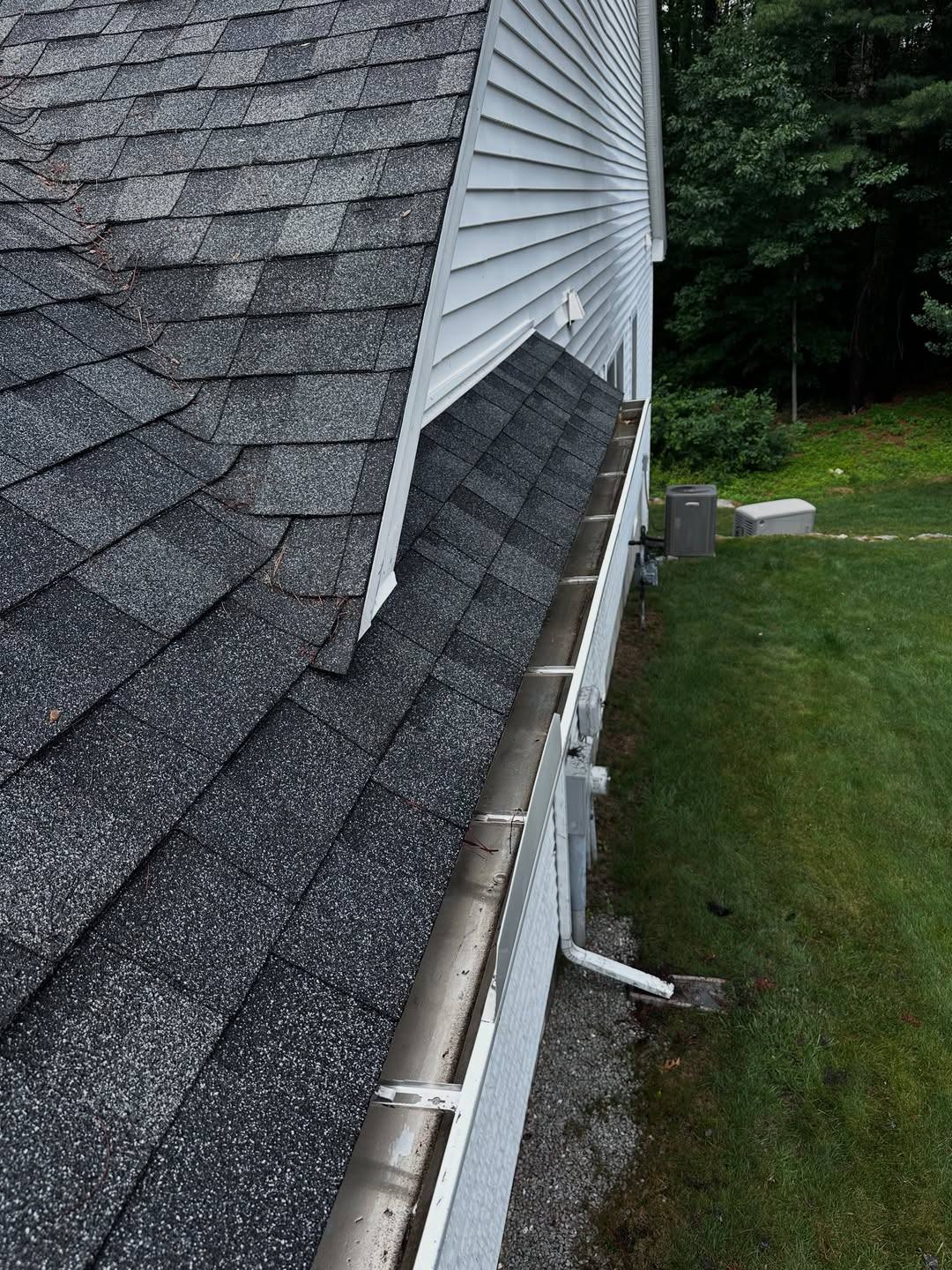 A gutter run cleared of pine needles, down to bare metal